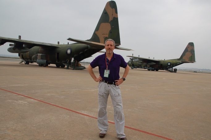 Andreas Landwehr vor Transportmaschine auf Flughafen von Kinmen